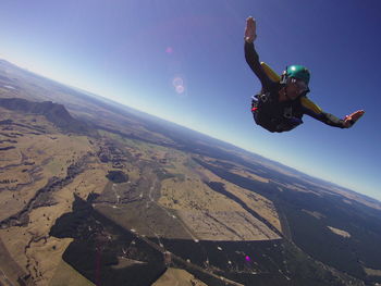 Man skydiving over landscape