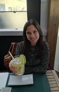 Portrait of smiling young woman sitting on table