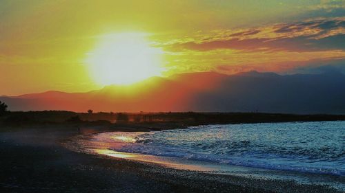 Scenic view of beach against dramatic sky