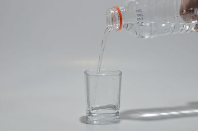 Close-up of wineglass on glass against white background