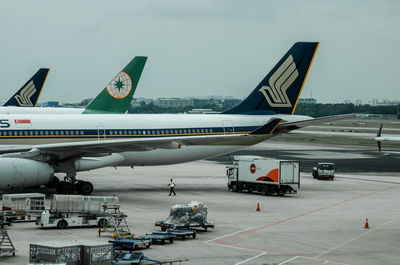 Airplane on airport runway against sky