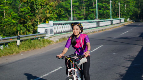 Portrait of smiling man riding bicycle on road