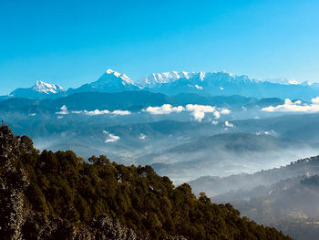 Scenic view of snowcapped mountains against blue sky