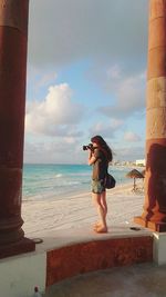 Woman photographing at beach
