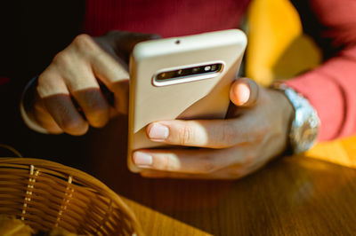 Man holding a phone at a restaurant table in vienna, austria