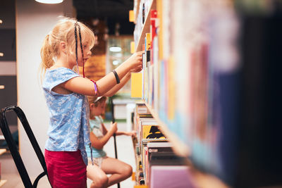 Schoolgirls looking for books in school library. students choosing books. elementary education