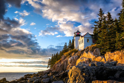 Lighthouse by sea against sky