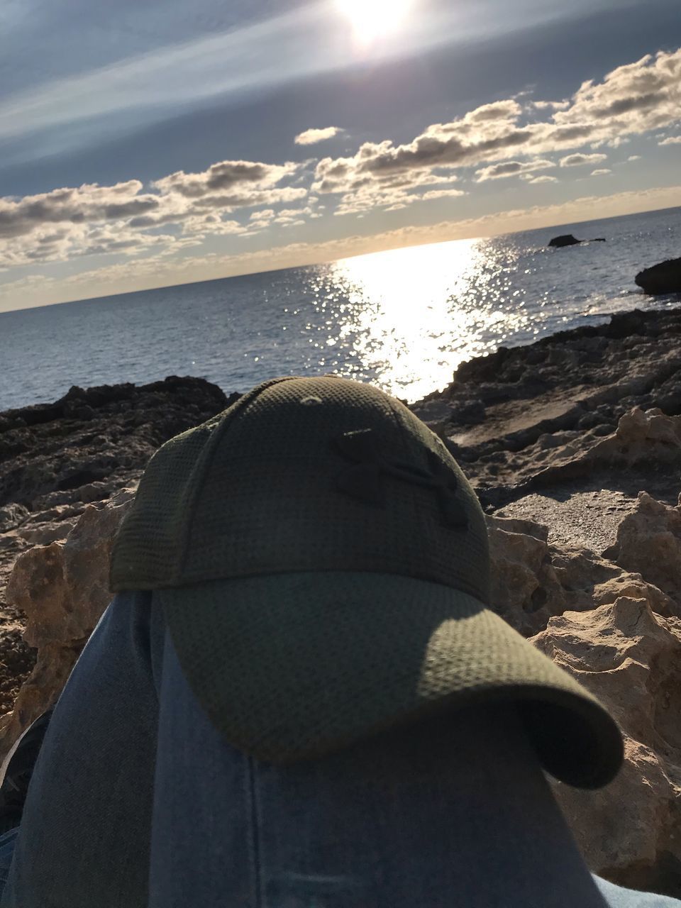 MIDSECTION OF MAN ON BEACH AGAINST SKY