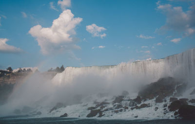 Scenic view of waterfall against sky