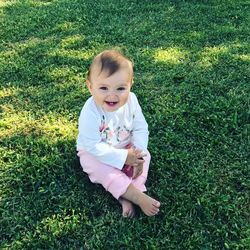 Portrait of cute boy standing on grassy field