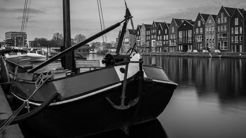 Boats moored in river against sky