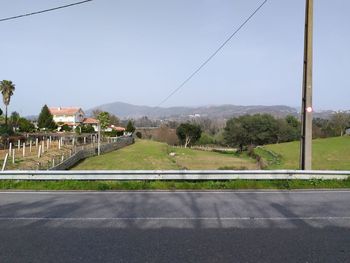 Road by street in city against sky