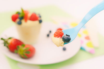 Close-up of dessert in spoon over bowl