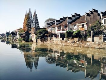 Reflection of buildings on lake against sky