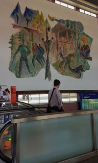 Rear view of man and woman standing against wall