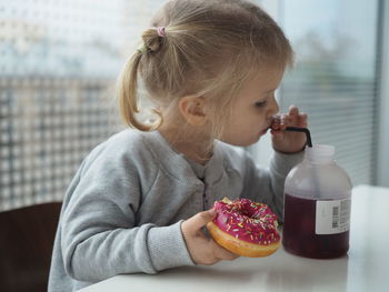 Girl eating doughnut at home