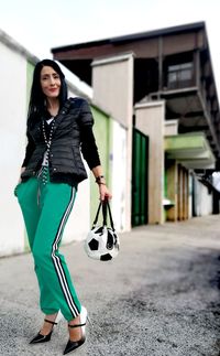 Portrait of fashionable woman standing on road