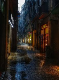 Wet street amidst buildings in city during rainy season