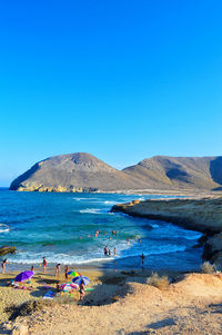 Scenic view of beach against clear blue sky