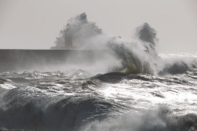 Water splashing in sea against clear sky