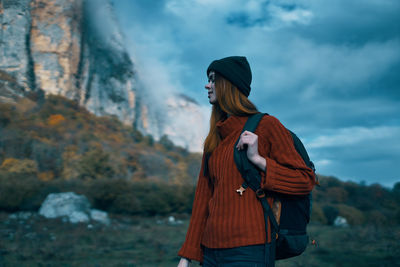 Rear view of woman standing against mountain