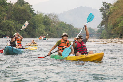 People rowing boat in river