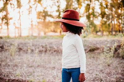 Side view of man wearing hat standing on land