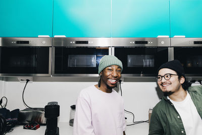 Happy male friends in kitchen at college dorm