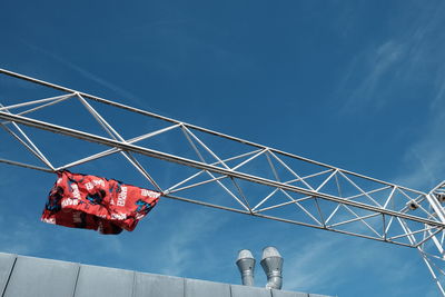 Low angle view of shorts hanging from metal against blue sky