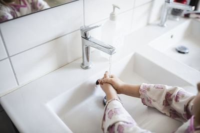 Young girl washes her hands