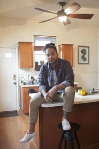 Portrait of young man sitting at home