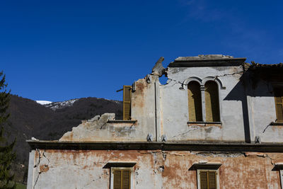 Low angle view of old building against clear blue sky