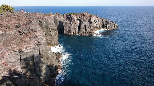 Rock formation in sea against sky