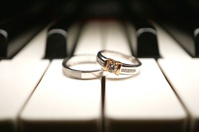 Close-up of wedding rings on piano keys