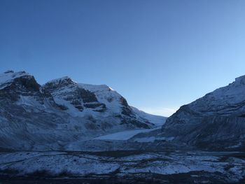 Scenic view of snowcapped mountains against clear blue sky