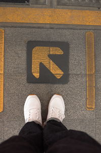 Low section of man standing on road