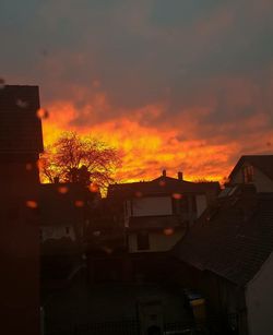 Houses against cloudy sky at sunset