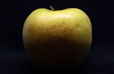 Close-up of apple on table against black background