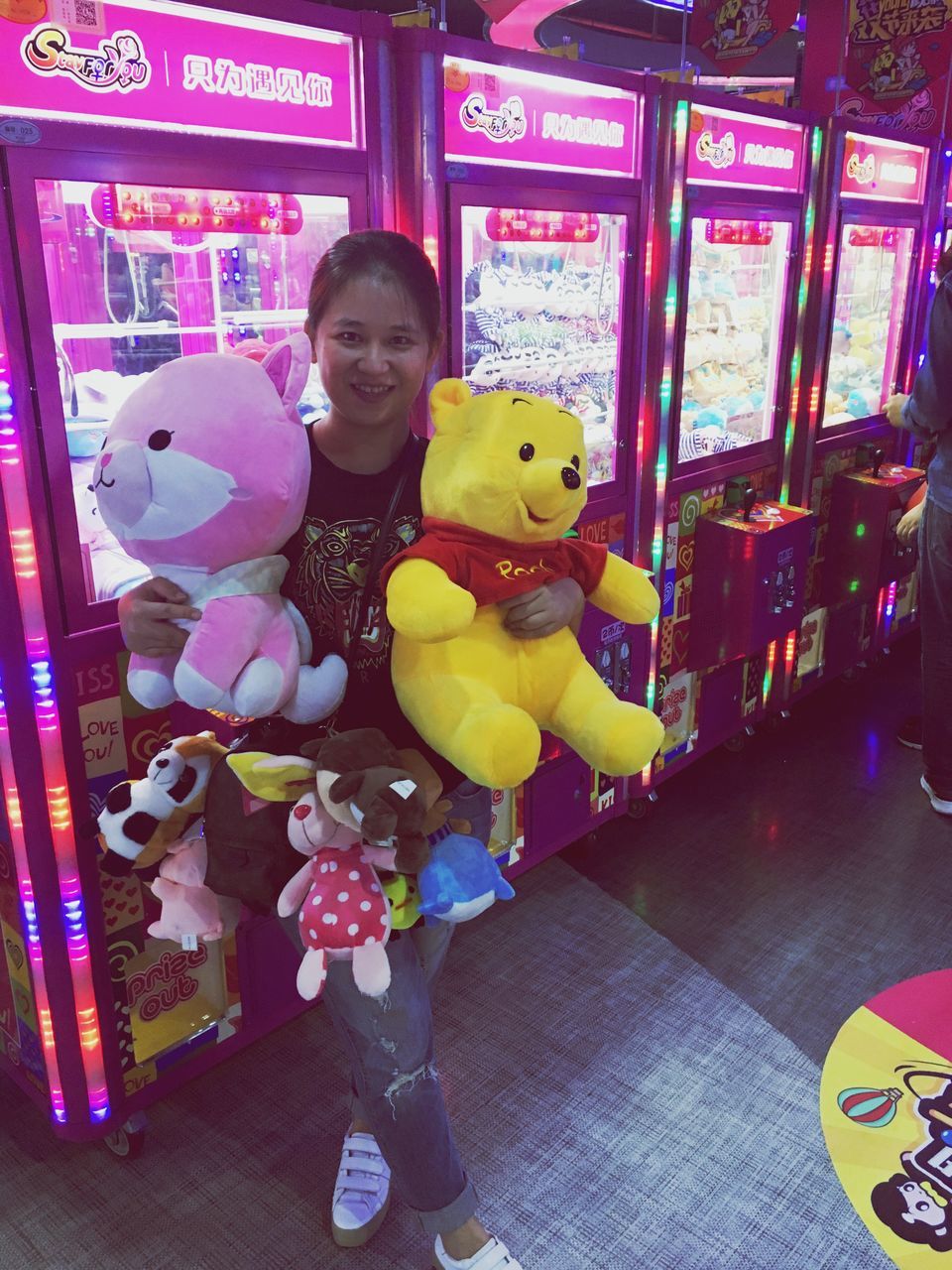 toy, indoors, childhood, smiling, happiness, real people, stuffed toy, enjoyment, lifestyles, teddy bear, full length, looking at camera, illuminated, multi colored, game, one person, day, people