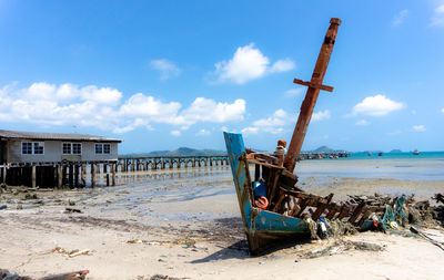 Abandoned built structure on beach against sky