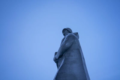 Low angle view of statue against blue sky