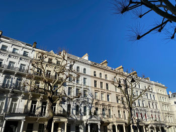 Low angle view of buildings against clear blue sky