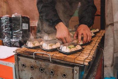 Midsection of man preparing food at market