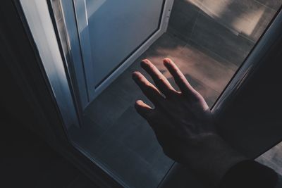 Low section of man holding glass window