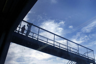 Low angle view of man on bridge against sky
