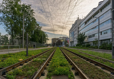 Railroad tracks in city against sky