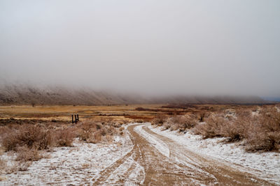 Road passing through snow covered land