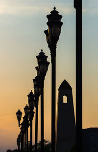 Illuminated street light against sky during sunset