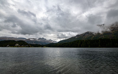 Scenic view of lake by mountains against sky