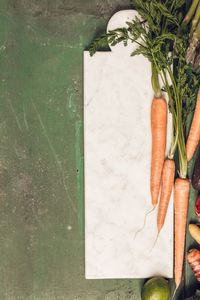 High angle view of vegetables and herbs with cutting board on table